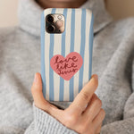 Christelijk hardcase telefoonhoesje Love Like Jesus met lichtblauwe strepen en hart. In hand van mevrouw