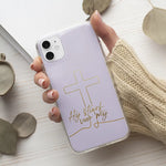 Softcase telefoonhoesje met de tekst “Hij stierf voor mij”, bladgoud letters op zachte roze achtergrond, stijlvol en betekenisvol. Het christelijke telefoonhoesje ligt in de hand. Met een kopje koffie erbij