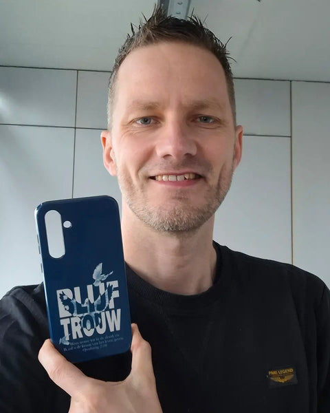 Christian Verwoerd houdt het Blijf trouw Openbaring 2:10 telefoonhoesje in zijn hand