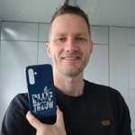 Christian Verwoerd houdt het Blijf trouw Openbaring 2:10 telefoonhoesje in zijn hand