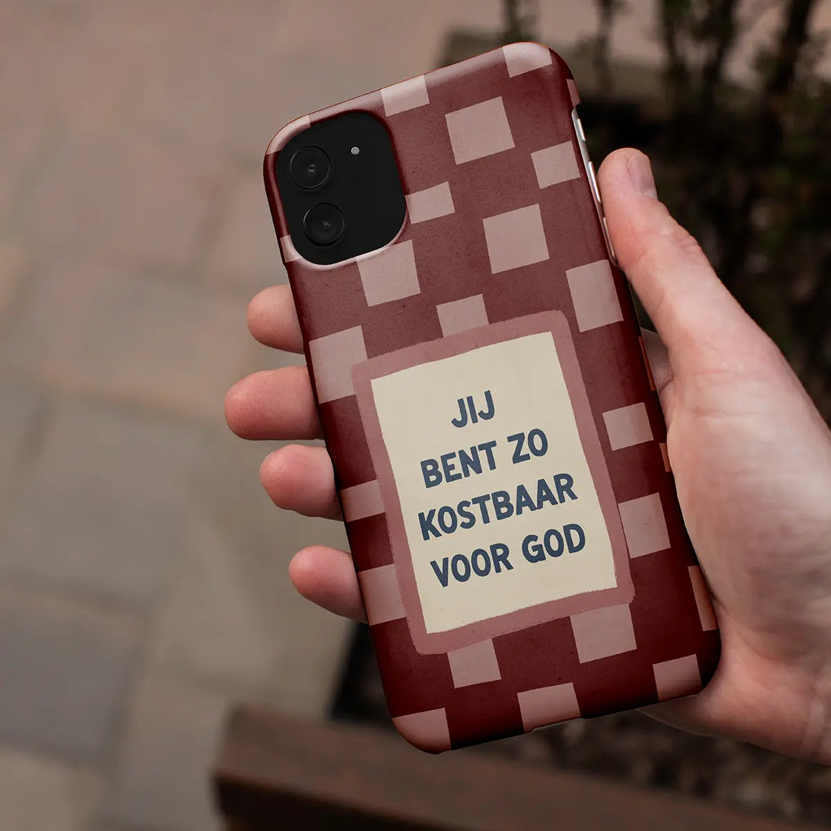 Christelijk softcase telefoonhoesje met de tekst “Jij bent zo kostbaar voor God” vastgehouden in een hand