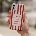 Christelijk softcase telefoonhoesje met de tekst By Grace Through Faith op rood gestreepte achtergrond in hand