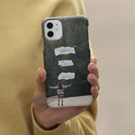Mockup van christelijk telefoonhoesje Spoiler Jesus wins in handen van vrouw met bos op achtergrond