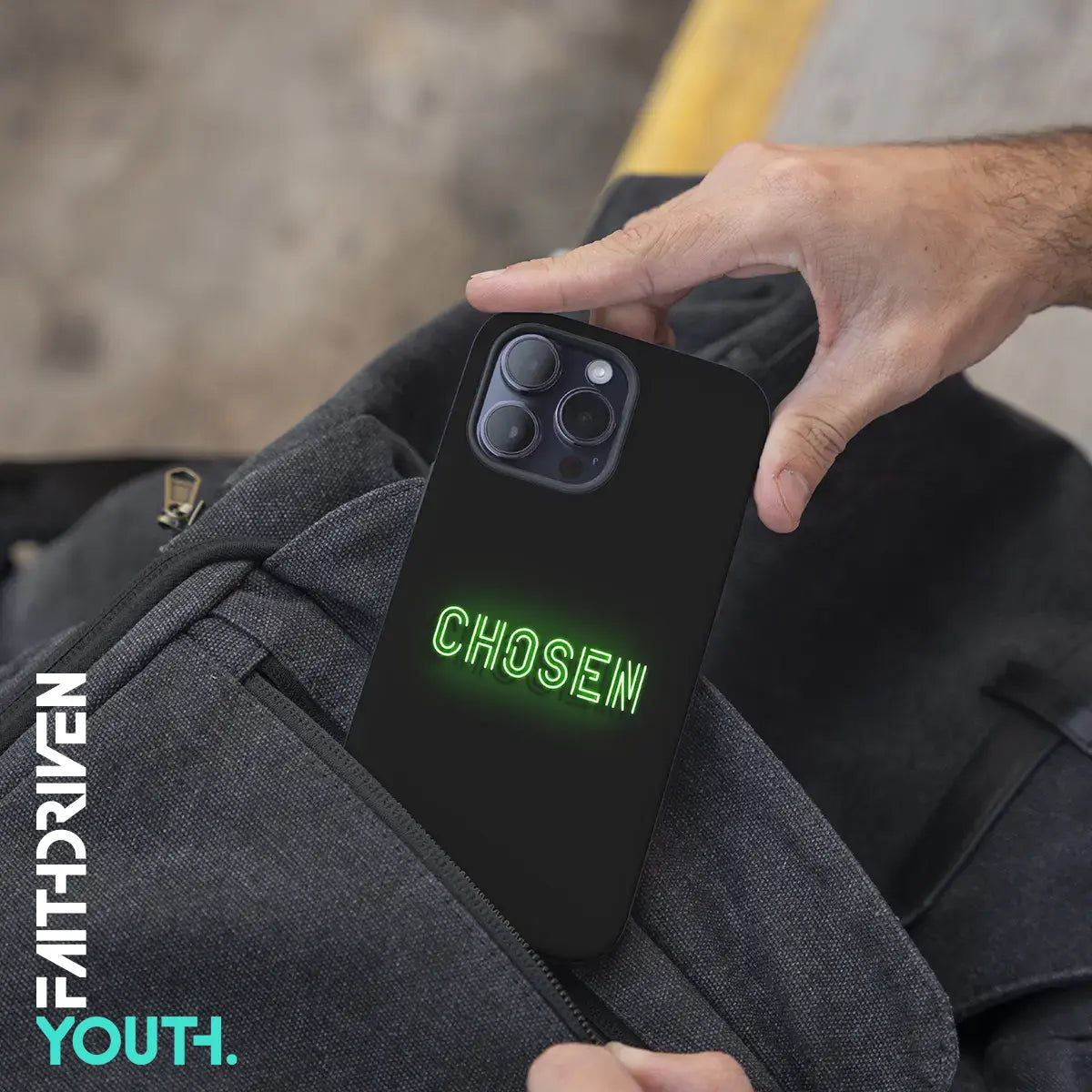 Hand haalt CHOSEN telefoonhoesje met neon-groene tekst uit een tas – modern christelijk design voor jongeren.