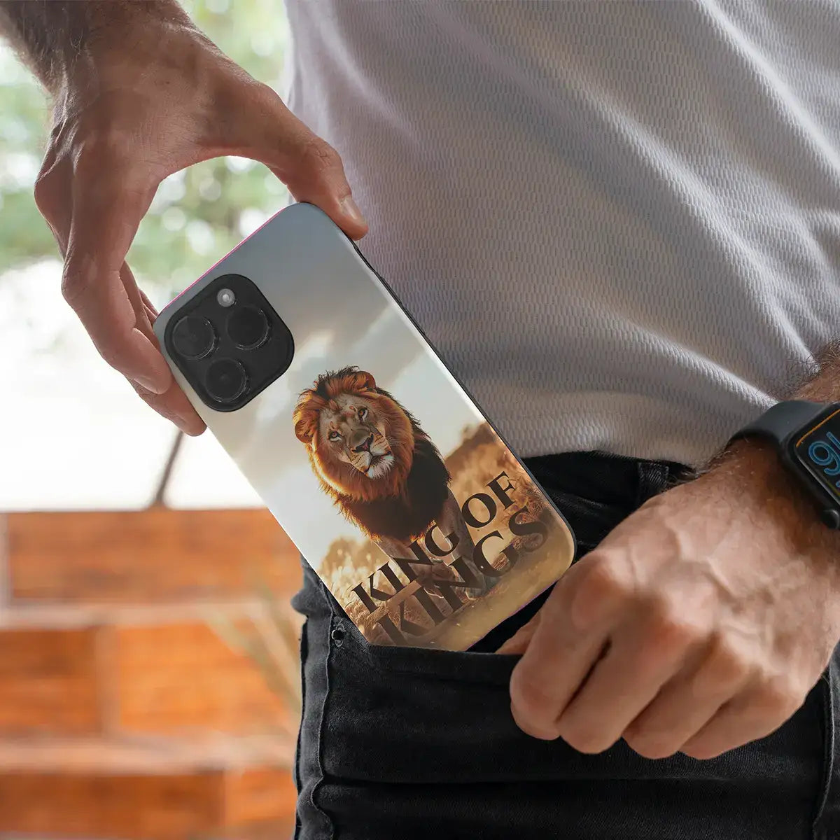 Man haalt telefoon met King of Kings christelijk softcase telefoonhoesje uit zijn broekzak
