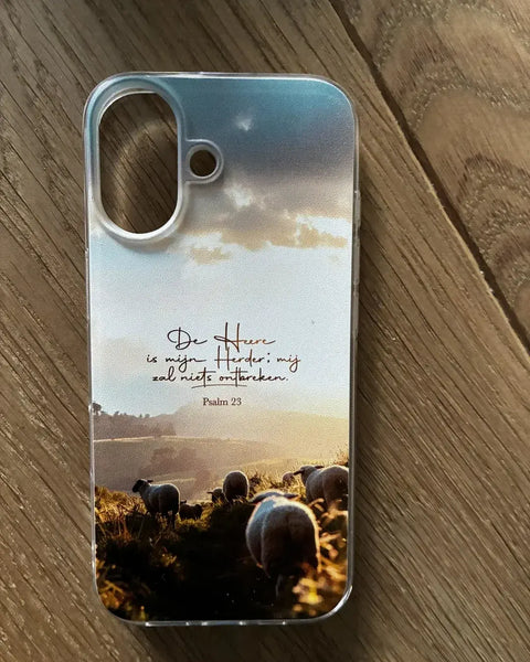 Transparant telefoonhoesje met Psalm 23, De Heere is mijn Herder, en grazende schapen bij zonsondergang