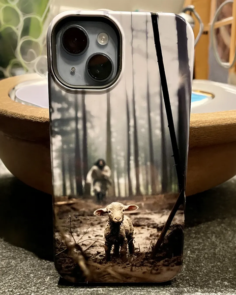 iPhone met telefoonhoesje van Jezus die in een mistig bos naar een verloren lammetje toe komt